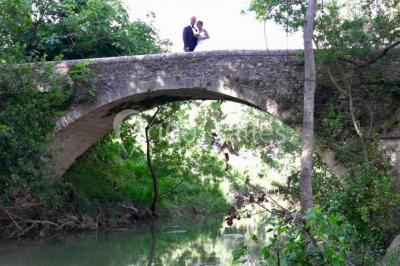 Un couple en tenue de mariage pose devant un groupe de cavaliers alignés sur des chevaux dans un espace verdoyant.