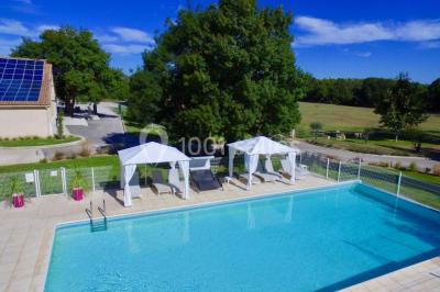 Un couple en tenue de mariage pose devant un groupe de cavaliers alignés sur des chevaux dans un espace verdoyant.