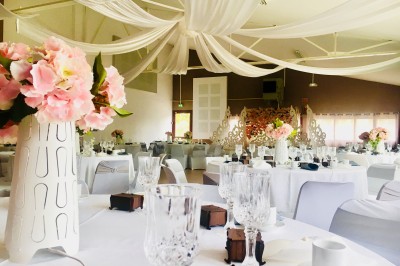 Un couple en tenue de mariage pose devant un groupe de cavaliers alignés sur des chevaux dans un espace verdoyant.