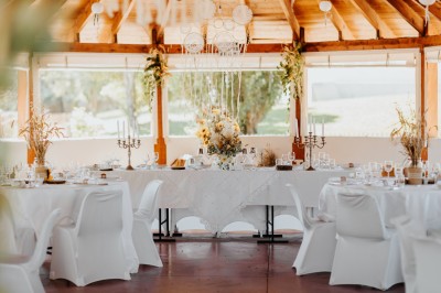 Un couple en tenue de mariage pose devant un groupe de cavaliers alignés sur des chevaux dans un espace verdoyant.