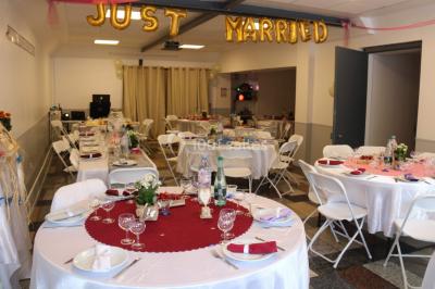 Salle lumineuse avec un grand miroir mural, sol en parquet clair et murs blancs, éclairée par des spots au plafond.