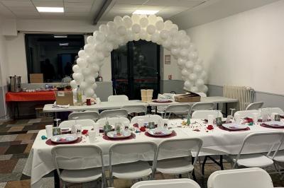 Salle lumineuse avec un grand miroir mural, sol en parquet clair et murs blancs, éclairée par des spots au plafond.
