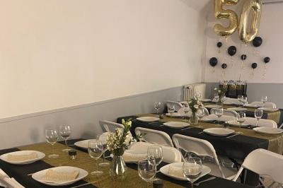 Salle lumineuse avec un grand miroir mural, sol en parquet clair et murs blancs, éclairée par des spots au plafond.