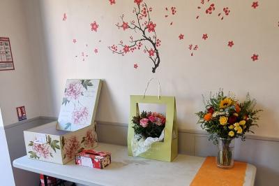 Salle lumineuse avec un grand miroir mural, sol en parquet clair et murs blancs, éclairée par des spots au plafond.