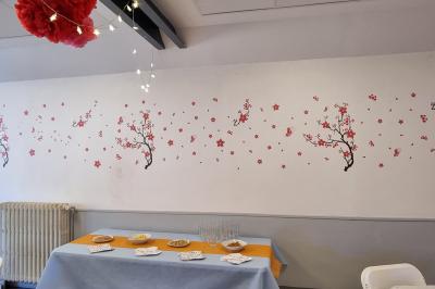 Salle lumineuse avec un grand miroir mural, sol en parquet clair et murs blancs, éclairée par des spots au plafond.