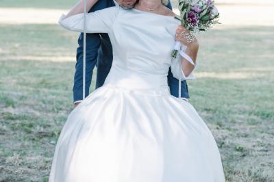 Façade d'une maison provençale avec terrasse ombragée, tables en fer forgé et grand arbre au premier plan.