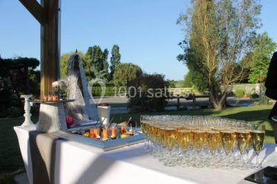 Voiture ancienne bleue décorée de rubans blancs et de fleurs pour une cérémonie, stationnée en extérieur.