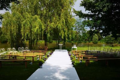 Voiture ancienne bleue décorée de rubans blancs et de fleurs pour une cérémonie, stationnée en extérieur.