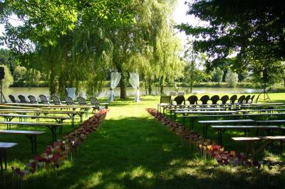 Voiture ancienne bleue décorée de rubans blancs et de fleurs pour une cérémonie, stationnée en extérieur.