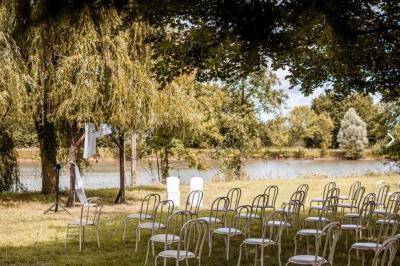 Voiture ancienne bleue décorée de rubans blancs et de fleurs pour une cérémonie, stationnée en extérieur.