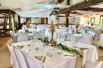 Voiture ancienne bleue décorée de rubans blancs et de fleurs pour une cérémonie, stationnée en extérieur.