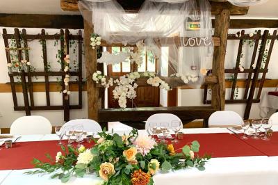 Voiture ancienne bleue décorée de rubans blancs et de fleurs pour une cérémonie, stationnée en extérieur.