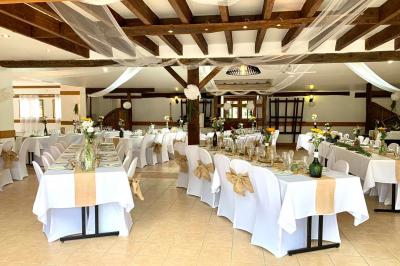 Voiture ancienne bleue décorée de rubans blancs et de fleurs pour une cérémonie, stationnée en extérieur.