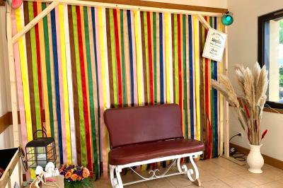 Voiture ancienne bleue décorée de rubans blancs et de fleurs pour une cérémonie, stationnée en extérieur.