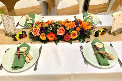 Voiture ancienne bleue décorée de rubans blancs et de fleurs pour une cérémonie, stationnée en extérieur.