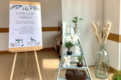 Voiture ancienne bleue décorée de rubans blancs et de fleurs pour une cérémonie, stationnée en extérieur.