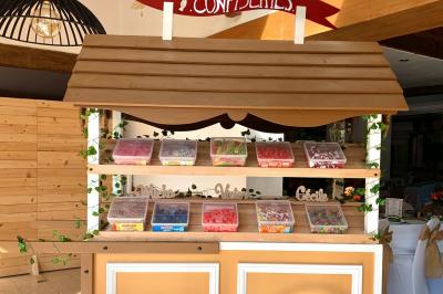 Voiture ancienne bleue décorée de rubans blancs et de fleurs pour une cérémonie, stationnée en extérieur.