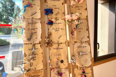 Voiture ancienne bleue décorée de rubans blancs et de fleurs pour une cérémonie, stationnée en extérieur.