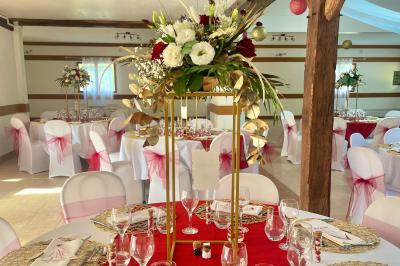 Voiture ancienne bleue décorée de rubans blancs et de fleurs pour une cérémonie, stationnée en extérieur.