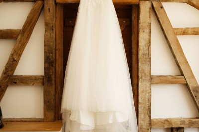 Voiture ancienne bleue décorée de rubans blancs et de fleurs pour une cérémonie, stationnée en extérieur.