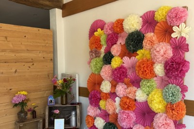 Voiture ancienne bleue décorée de rubans blancs et de fleurs pour une cérémonie, stationnée en extérieur.