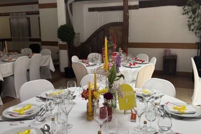 Voiture ancienne bleue décorée de rubans blancs et de fleurs pour une cérémonie, stationnée en extérieur.