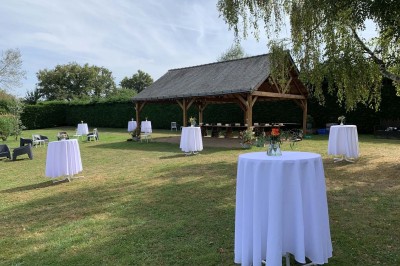 Voiture ancienne bleue décorée de rubans blancs et de fleurs pour une cérémonie, stationnée en extérieur.