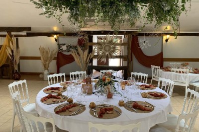 Voiture ancienne bleue décorée de rubans blancs et de fleurs pour une cérémonie, stationnée en extérieur.
