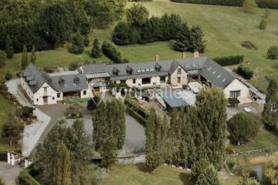Voiture ancienne bleue décorée de rubans blancs et de fleurs pour une cérémonie, stationnée en extérieur.