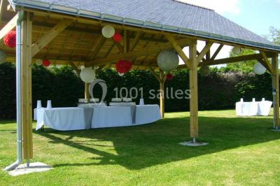 Voiture ancienne bleue décorée de rubans blancs et de fleurs pour une cérémonie, stationnée en extérieur.