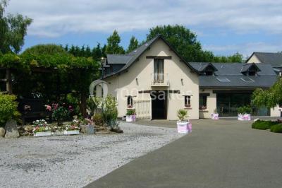 Voiture ancienne bleue décorée de rubans blancs et de fleurs pour une cérémonie, stationnée en extérieur.