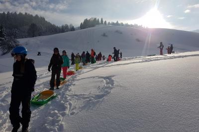 Plat de fromage fondu servi dans des ramequins en terre cuite sur une table en bois, avec du vin rouge et du pain.