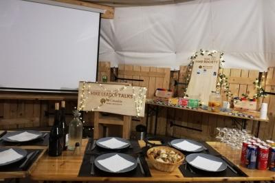 Plat de fromage fondu servi dans des ramequins en terre cuite sur une table en bois, avec du vin rouge et du pain.