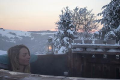 Groupe de personnes rassemblées en extérieur près de tentes et d'une table avec des verres, dans un cadre naturel.
