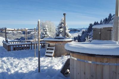 Groupe de personnes rassemblées en extérieur près de tentes et d'une table avec des verres, dans un cadre naturel.