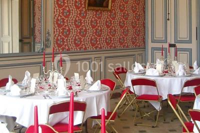 Chambre lumineuse avec lit à baldaquin, armoire à miroir, chaise en bois et rideaux rouges encadrant une fenêtre ouverte.
