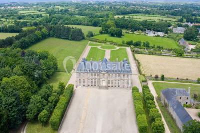 Chambre lumineuse avec lit à baldaquin, armoire à miroir, chaise en bois et rideaux rouges encadrant une fenêtre ouverte.