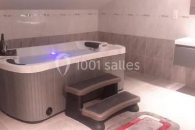 Miniature Location salle Onzain (Loir-et-Cher) - Le Manoir du Moulin #21 Vue depuis une terrasse rouge sur un petit cours d'eau bordé d'arbres, avec des maisons en arrière-plan.