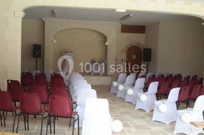 Miniature Location salle Onzain (Loir-et-Cher) - Le Manoir du Moulin #14 Vue depuis une terrasse rouge sur un petit cours d'eau bordé d'arbres, avec des maisons en arrière-plan.