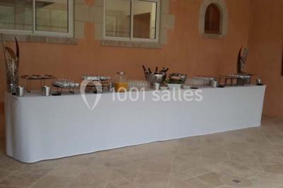 Miniature Location salle Onzain (Loir-et-Cher) - Le Manoir du Moulin #15 Vue depuis une terrasse rouge sur un petit cours d'eau bordé d'arbres, avec des maisons en arrière-plan.