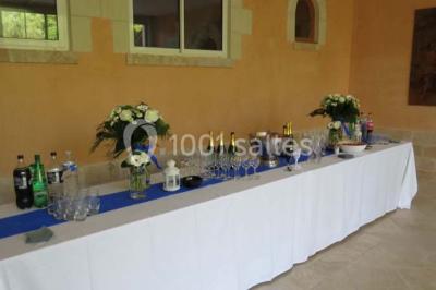 Miniature Location salle Onzain (Loir-et-Cher) - Le Manoir du Moulin #13 Vue depuis une terrasse rouge sur un petit cours d'eau bordé d'arbres, avec des maisons en arrière-plan.