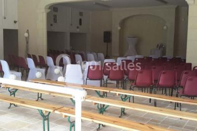 Miniature Location salle Onzain (Loir-et-Cher) - Le Manoir du Moulin #18 Vue depuis une terrasse rouge sur un petit cours d'eau bordé d'arbres, avec des maisons en arrière-plan.