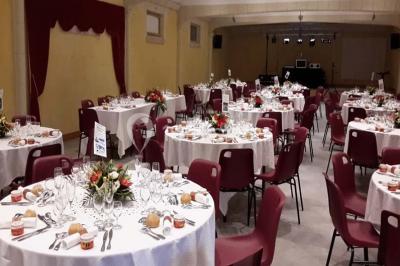 Miniature Location salle Onzain (Loir-et-Cher) - Le Manoir du Moulin #4 Vue depuis une terrasse rouge sur un petit cours d'eau bordé d'arbres, avec des maisons en arrière-plan.