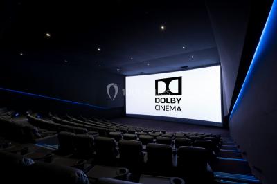 Vue intérieure d'un espace de loisirs avec sièges, tables, escalier central et décorations colorées sous un plafond haut.