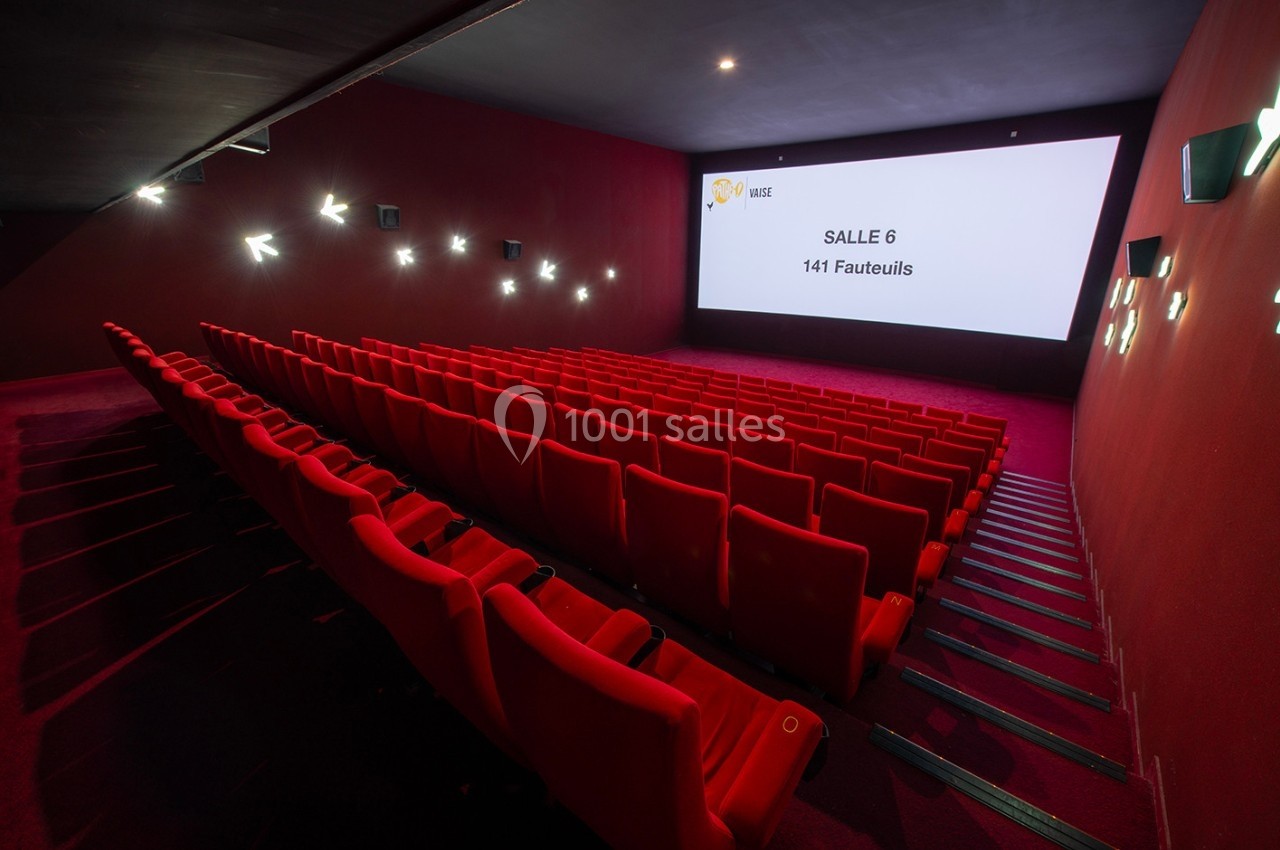 Salle de cinéma vide avec des rangées de fauteuils rouges et un écran affichant ’Salle 6 - 141 Fauteuils’.