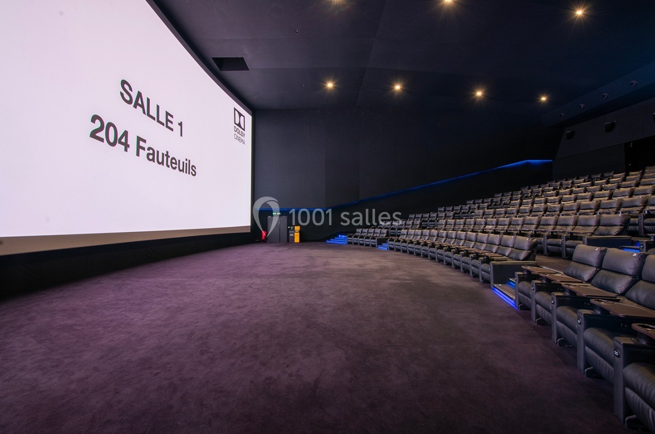 Salle de cinéma moderne avec écran géant, 204 fauteuils et éclairage tamisé.