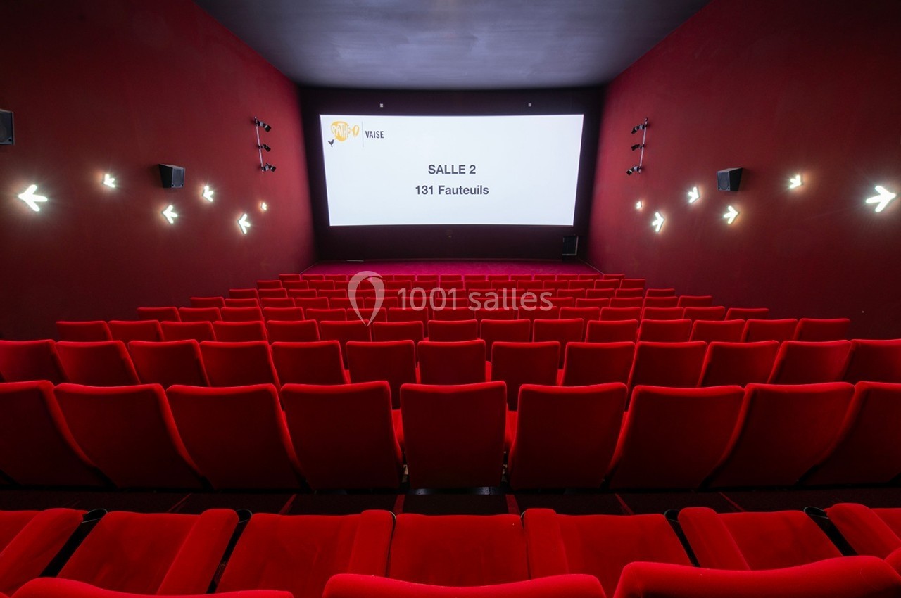 Salle de cinéma vide avec des rangées de fauteuils rouges et un écran affichant ’Salle 2 - 131 Fauteuils’.
