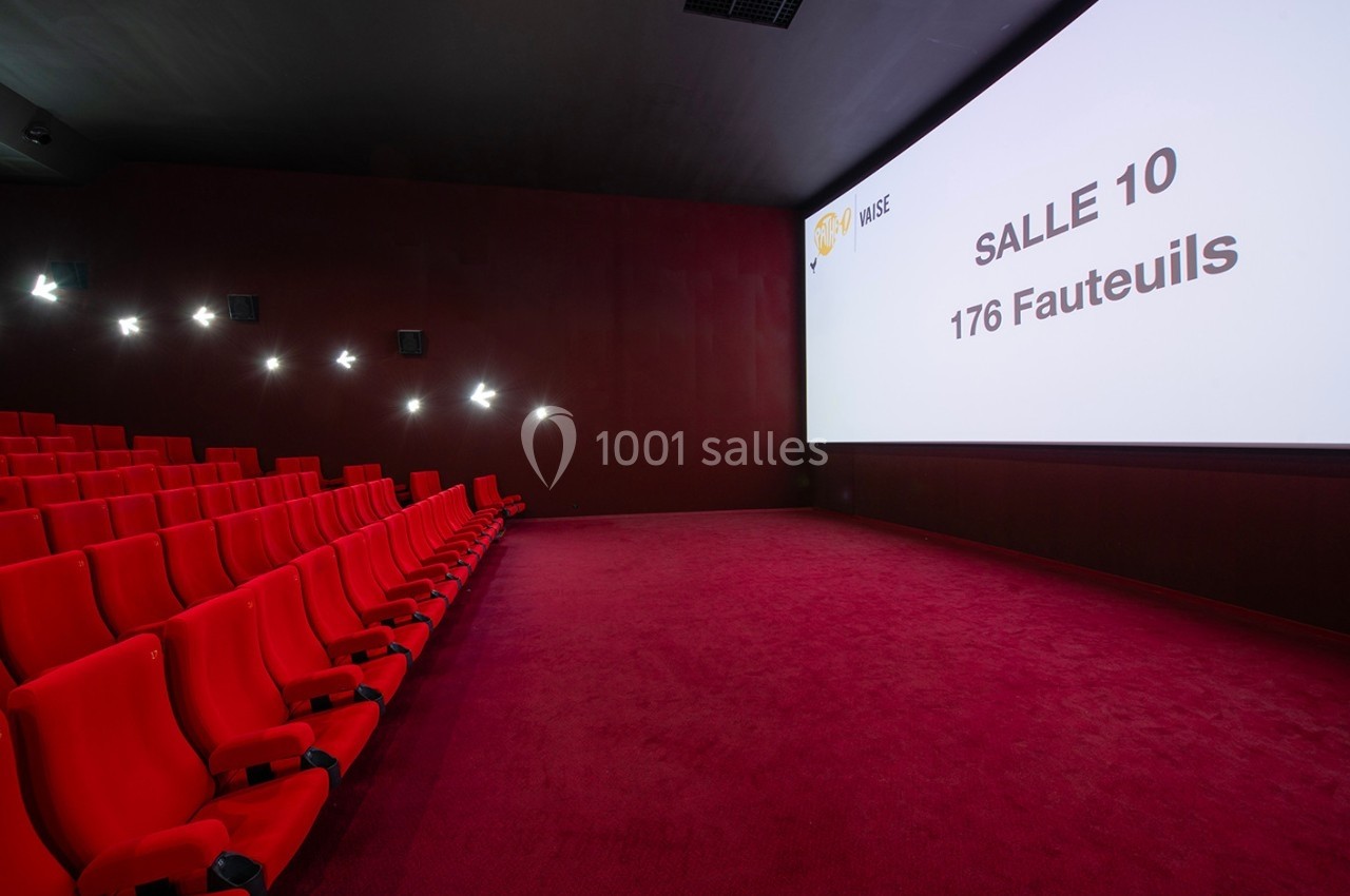 Salle de cinéma vide avec des sièges rouges alignés et un écran affichant ’Salle 10, 176 fauteuils’.