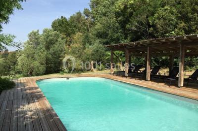 Église en briques rouges avec clocher-mur, entourée d'arbres et située dans un environnement rural.