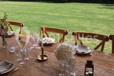 Église en briques rouges avec clocher-mur, entourée d'arbres et située dans un environnement rural.